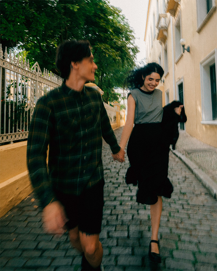 Casal caminhando por rua de paralelepípedo — ensaio pré-wedding